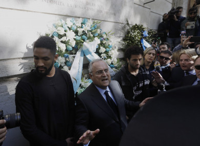 Claudio Lotito (center), accompanied by Lazio players Felipe Anderson (right) and Wallace (left), gives a statement to the press after laying a wreath outside Rome's Synagogue.