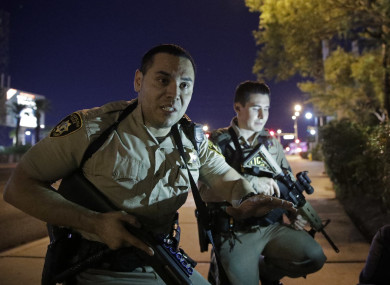 Police officers advise people to take cover near the scene of a shooting.