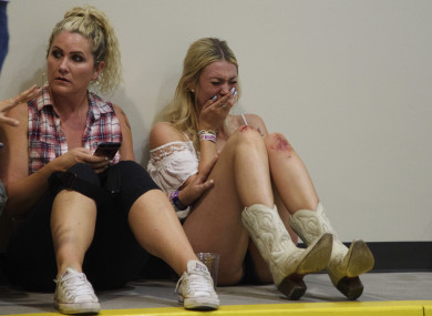 A woman cries while hiding inside the Sands Corporation plane hangar after a lone gunman fired upon the Route 91 Harvest country festival.