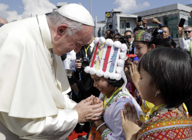 Pope Francis is greeted by young children in traditional clothes upon his arrival at Yangon's airport, Myanmar.
