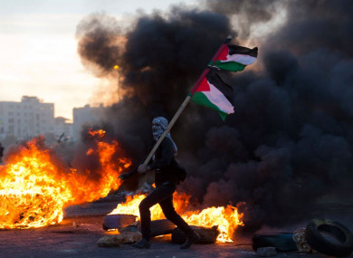 A Palestinian protester pictured yesterday during clashes with Israeli troops following protests against Trump's decision