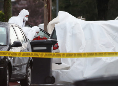 Gardai look into the car with a shattered window on McKee Road ,Finglas where Vincent Ryan was killed.
