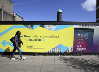 A file photo of a person walks past a sign for new student accommodation in Dublin (file photo).