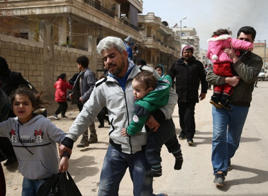 Civilians run for cover from explosions in the city of Afrin in northern Syria today, after Turkish forces and their rebel allies took control of the Kurdish-majority city.