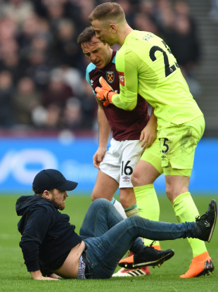 Mark Noble shouts at a West Ham fan after he invaded the pitch today.