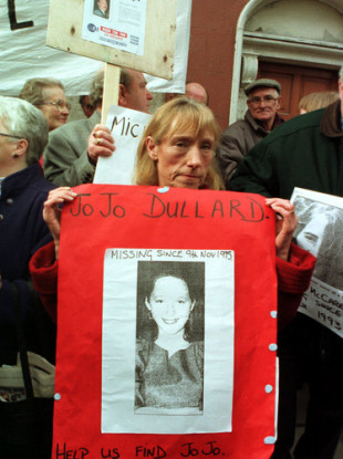 Mary Phelan holding a poster of her sister in 1997.