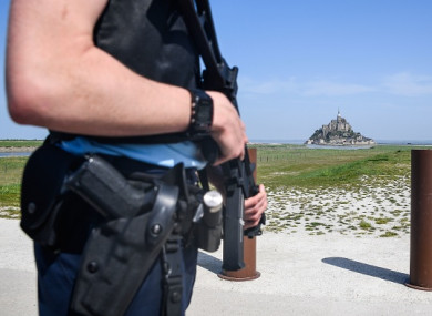 An armed officer stands by the road leading to Mont Saint-Michel after it was evacuated today