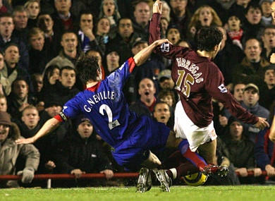 Gary Neville challenges Cesc Fabregas.
