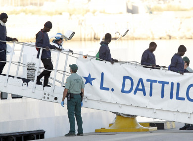 Migrants descend the Italian coast guard vessel Dattilo.