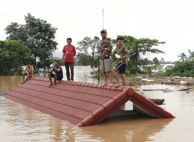 Villagers take refuge on a rooftop above flood waters from a collapsed dam in the Attapeu district of southeastern Laos.