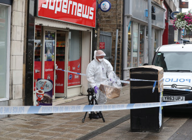 A forensic officer checks a bin in Peel Square in Barnsley town centre after a serious incident.