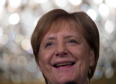 German Chancellor Angela Merkel smiles when answering question today.