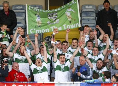 Portlaoise's Paul Cahillane and David Holland raise the trophy at the end of the game.