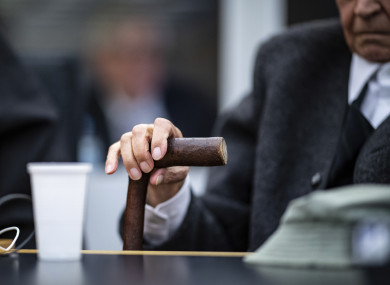 A 94-year-old former SS guard holds his walking stick at the beginning of a trial in Muenster, Germany.