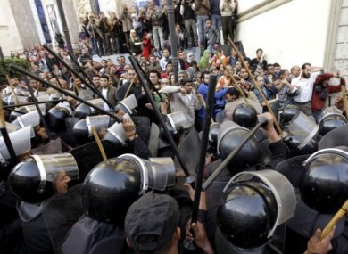 Egyptian anti-riot police confront Egyptian activist outside a journalists syndicate in downtown Cairo, Egypt, Wednesday, Jan. 26, 2011.