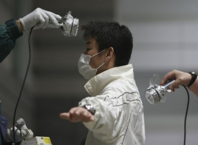A man is screened for radiation contamination at an evacuation shelter in Koriyama, Fukushima prefecture, Japan, Saturday, April 2, 2011.
