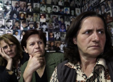 Women from Srebrenica sit in a room covered with pictures of victims of the 1995 massacre, and watch a tv broadcast of Mladic's court proceedings at The Hague.