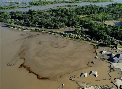 Oil swirls in a flooded gravel pit in Lockwood, Montana after crude oil pipeline ruptures in river.