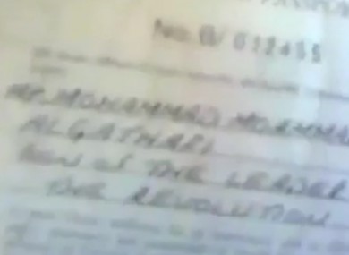 Still from a video which shows somebody flicking through the Libyan leader's diplomatic passport.