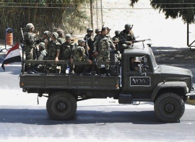 In this citizen journalism image, Syrian troops withdraw from the Damascus suburb of Saqba, Syria, on Sunday Aug. 14, 2011
