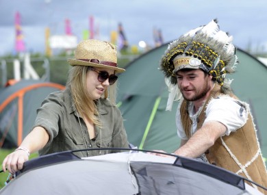 Big Chief Dago, aka Barry Davenport from Dublin, helps Brett O'Mahony from Clare put up her tent at the Electric Picnic today.
