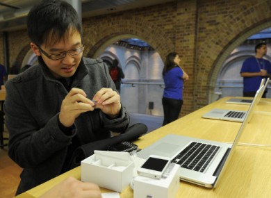 Kit Tjia, 22 from Wembley switches his Blackberry for a new iPhone 4S at the Apple store in Covent Garden, London. Tija did not say whether this was because of the recent outages.