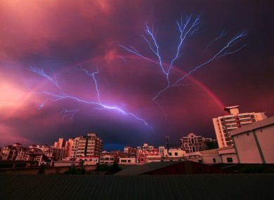 Lightning and a rainbow appear simultaneously during a storm in Haikou, China