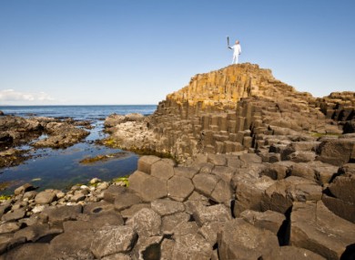 Torchbearer Peter Jack carrying the flame at the Giant's Causeway yesterday.