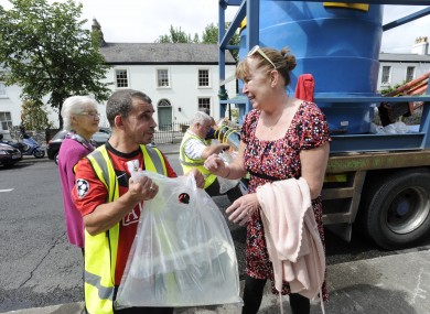 Local resident Rosemary McGinn collects water from a city council tanker on Castle Avenue yesterday.