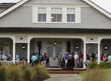 Golfers wait out the rain on the clubhouse porch during a weather-delayed practice round at the PGA Championship golf tournament on the Ocean Course of the Kiawah Island GC.