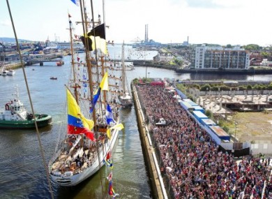 Crowds watch the ships as they sail out of Dublin Harbour on Sunday.