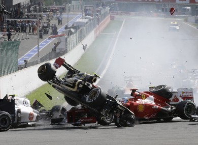 Lotus driver Romain Grosjean of France, top left, crashes with Ferrari driver Fernando Alonso of Spain, during the first lap of the Belgium Formula One Grand Prix in Spa-Francorchamps circuit.