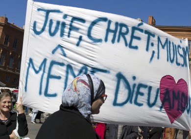People gather to pay their respects to the shooting victims of Mohamed Merah in Toulouse. Banner reads: