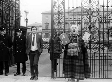 Opposition chief whip Bertie Ahern takes a breather from Dáil debates on the right-to-life referendum, as pro-life activist Margaret Mary Dunne campaigns outside.