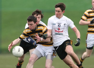 Colaiste Eoin's Dara O'Caomhanaigh tackled by Cian Scanlon and Ben McCormack of Newbridge.