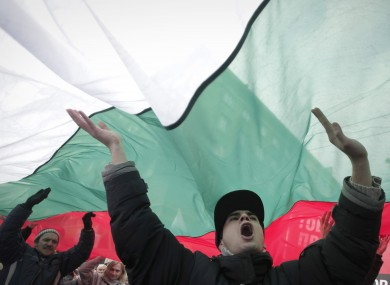 Bulgarian shouts slogans as they carry giant Bulgarian flag during a protest in Sofia.