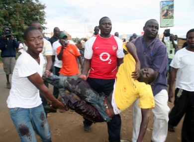 A protester is helped by others after he was shot by police in Kondele, Kisumu, Saturday, March 30, 2013 after Supreme Court declared President elect Uhuru Kenyatta as the fourth president of the Republic of Kenya.