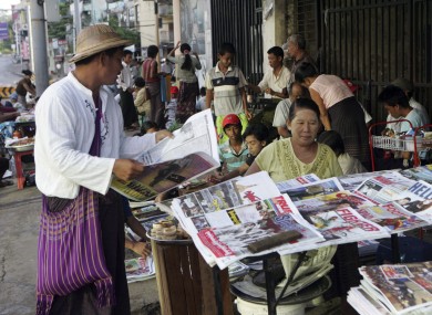 A man buys a weekly news journal at a roadside newspaper stand in Yangon. Only state-sponsored titles are allowed to publish daily - a regime that will end from tomorrow.
