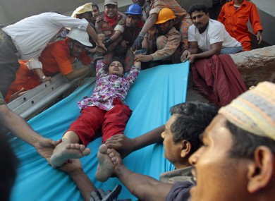 Rescuers lower down a survivor from the debris of a building that collapsed in Savar, near Dhaka.