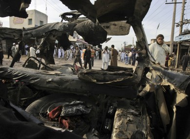 Pakistani men are seen through the wreckage of a vehicle at the site of a bomb explosion, in Peshawar, Pakistan, last Saturday (file photo).