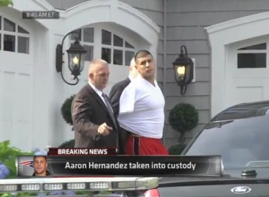 Hernandez is led away by police.
