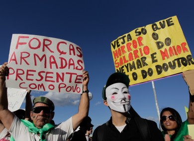 Demonstrators with posters that on the left say