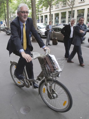 British Cycling President, Brian Cookson, rides a bike as he poses for photographers after a press conference in Paris earlier.