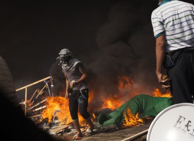 A supporter of ousted Egyptian President Mohammed Morsi passes a fire barricade carrying a gasoline bomb during clashes against security forces in Cairo's Nasr City district.
