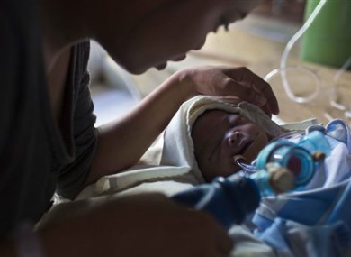 Genia Mae Mustacisa pumps oxygen into the lungs of her three-day-old infant in front of the altar of a Catholic chapel inside the Eastern Visayas Regional Medical Center in Tacloban
