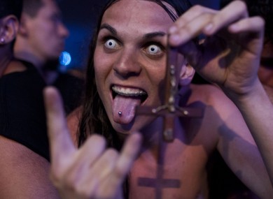 A fan holds a cross upside down during the Rock in Rio music festival in Rio de Janeiro last year where Muse, Justin Timberlake, Metallica, Bon Jovi, and Bruce Springsteen all played.