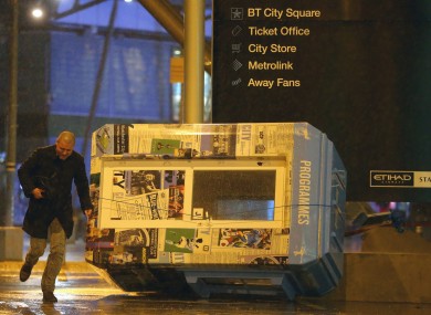 A programme stand blown over amidst the heavy wind and rain outside the Etihad Stadium.