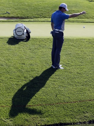 Rory McIlroy takes a drop on 14 after finding the water.