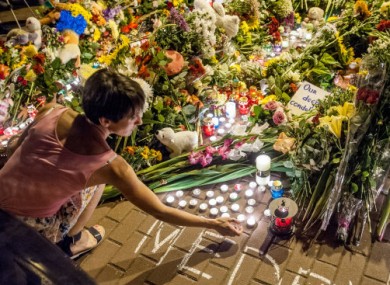 A woman lights a candle outside the Embassy of the Netherlands in Kiev to commemorate victims of Malaysia Airlines Flight MH17.
