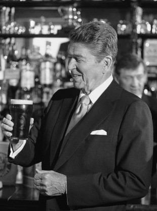US President Ronald Reagan contemplates a pint glass of Irish stout, at the bar of O'Farrells Pub in the centre of the village of Ballyporeen in 1984.